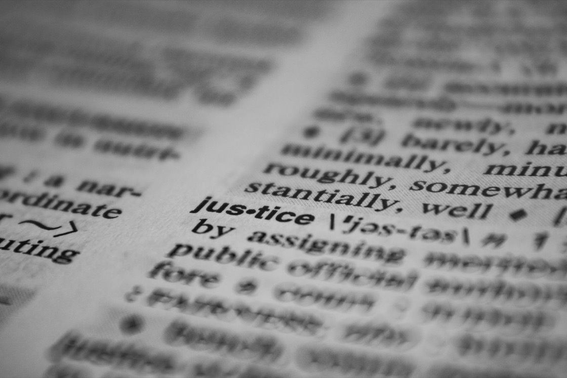 Close-up of a dictionary page, with the entry for the word justice in focus